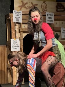 A clown rides another clown like a horse.