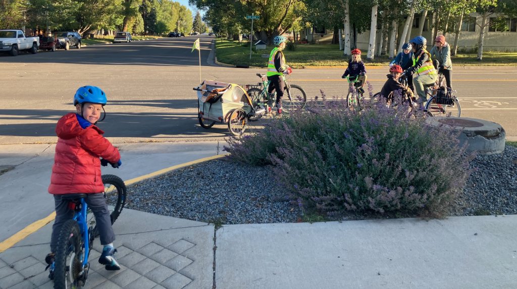 community school students and adult volunteers bike to school
