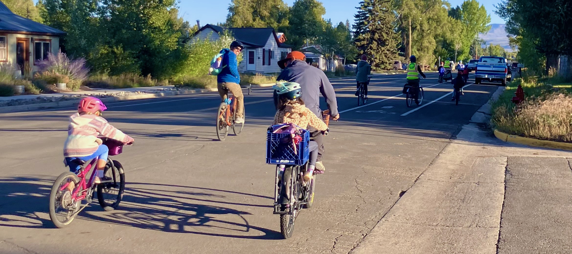 adult volunteers and community school students bike to school