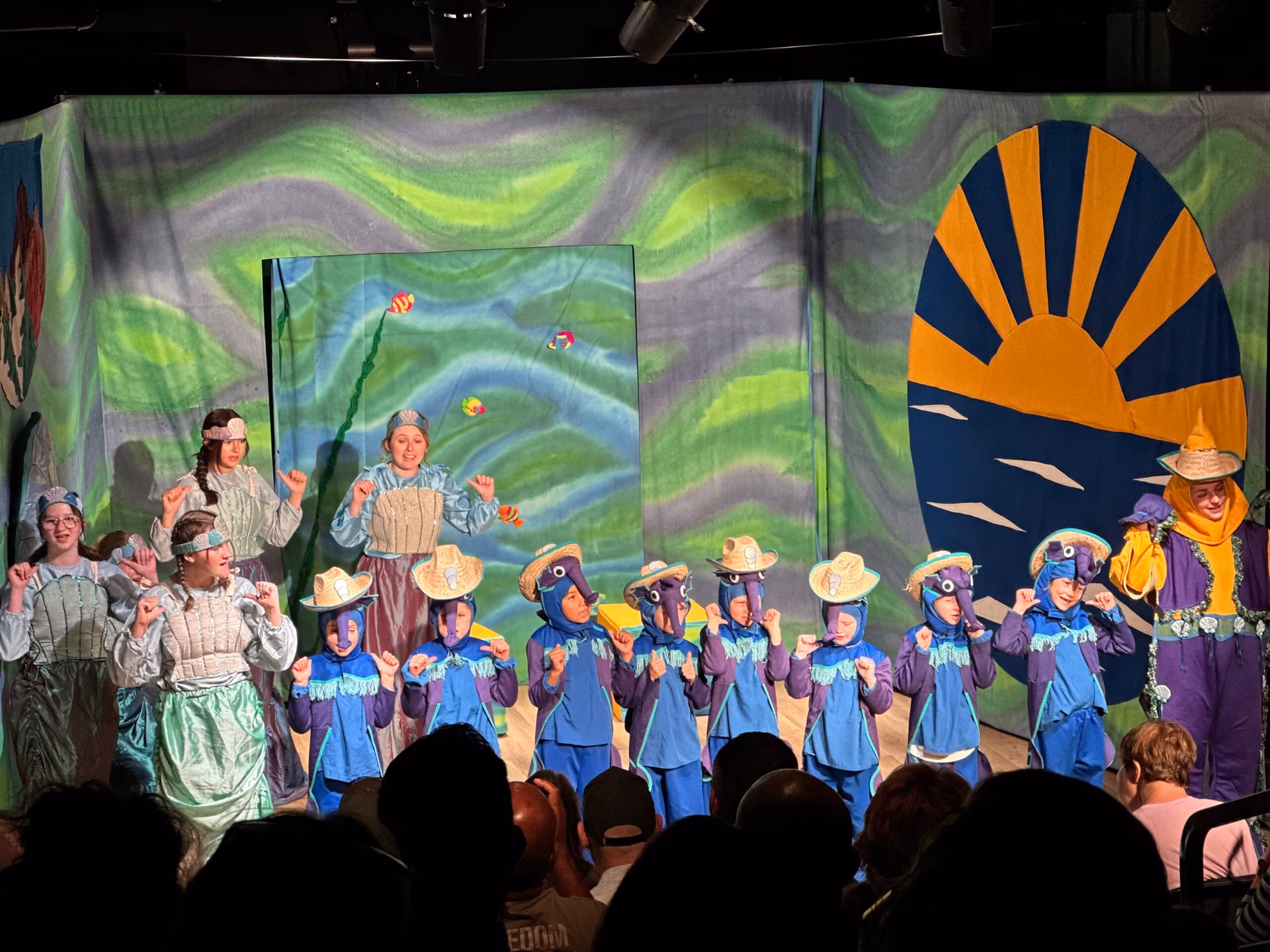 Youth perform The Little Mermaid on stage.