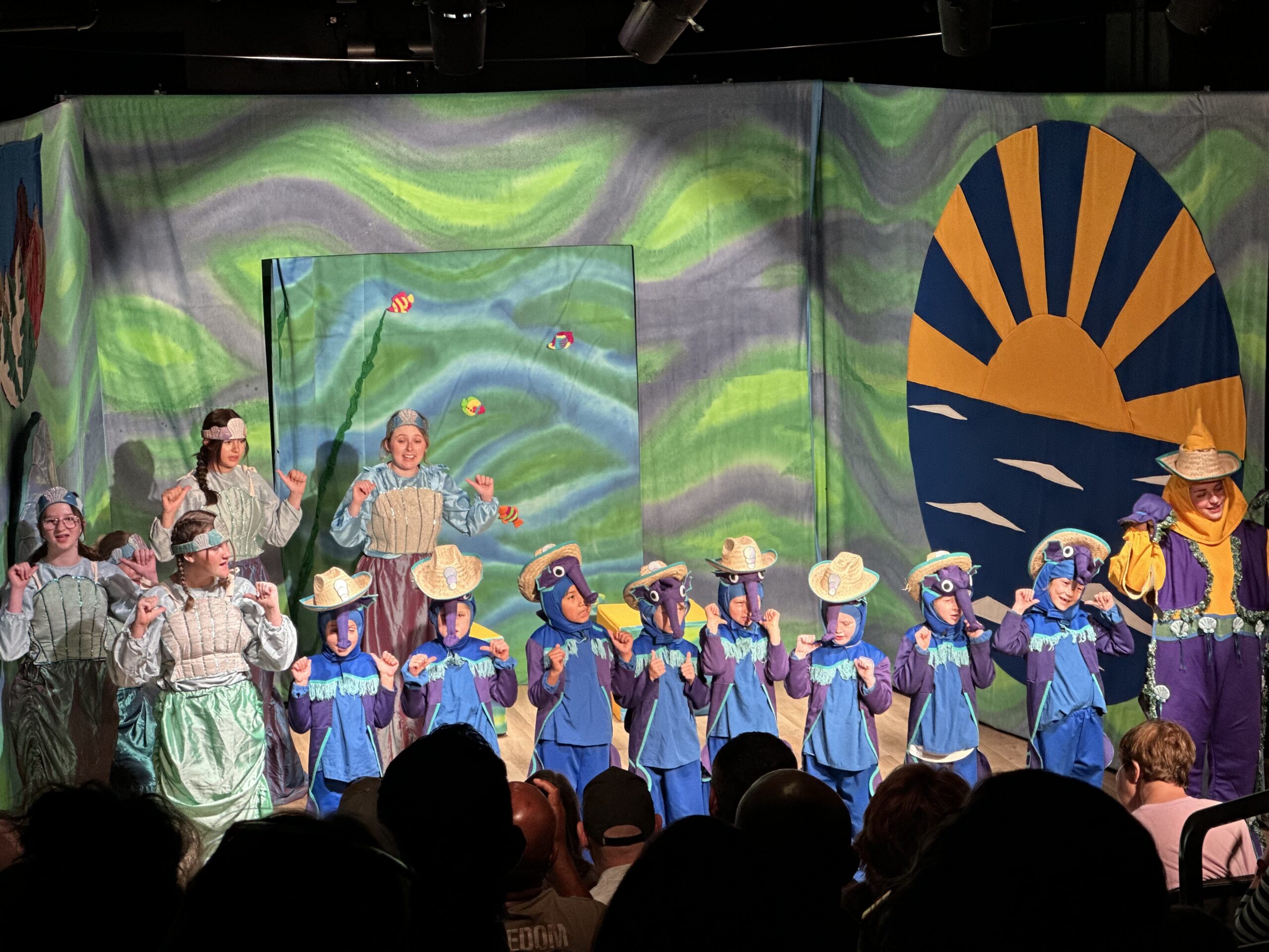 Youth perform The Little Mermaid on stage.